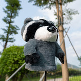 Plush raccoon toy on a stand with a park background